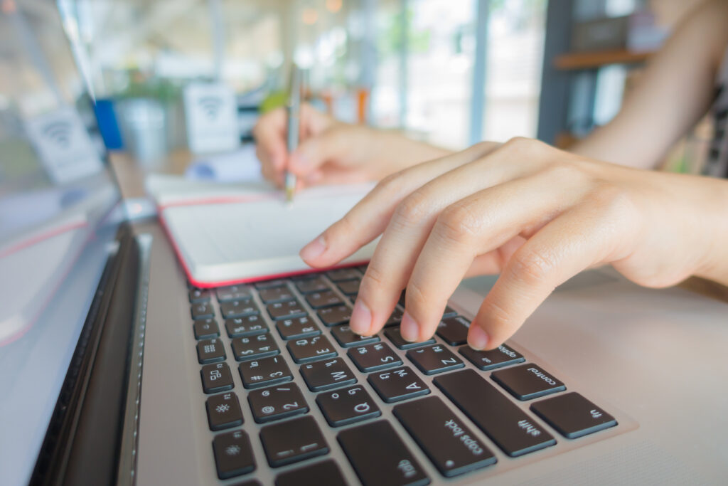 Closeup of business woman hand typing on laptop keyboard .